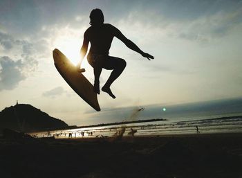 Full length of silhouette person jumping on beach