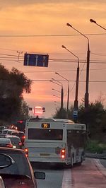 Cars on road against sky at sunset