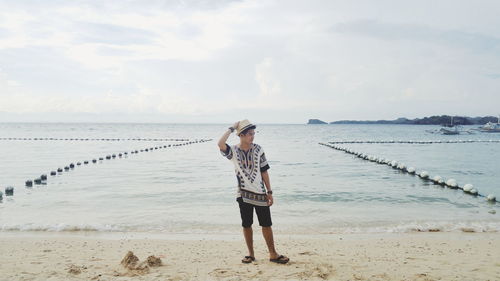 Full length of young man standing at beach
