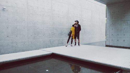 Full length of young man standing against building