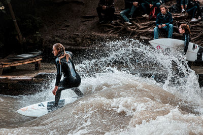 Young woman splashing water at shore