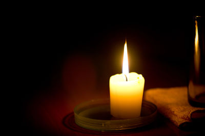 Close-up of lit candle in the dark