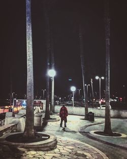 Man on illuminated road at night