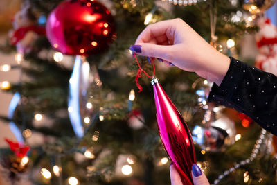 Hanging baubles on the christmas tree, women's tiles, painted nails christmas tree