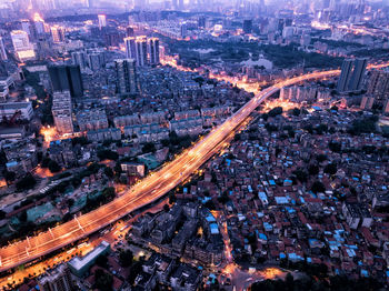 Aerial view of bridge amidst cityscape at dusk