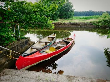 Boat moored on river by trees