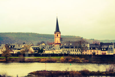 River amidst buildings in city against sky