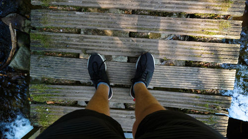 Low section of man standing on wooden floor