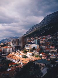 Buildings in town against cloudy sky