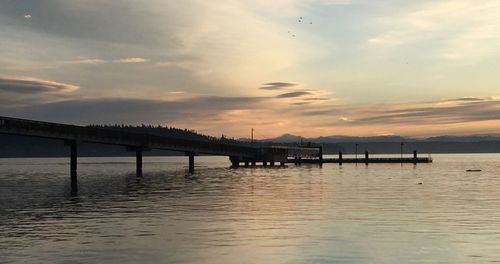 Pier on sea at sunset