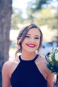 Portrait of smiling teenage girl with bouquet 