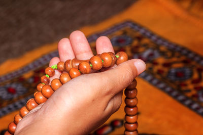 Close-up of hand holding prayer beads