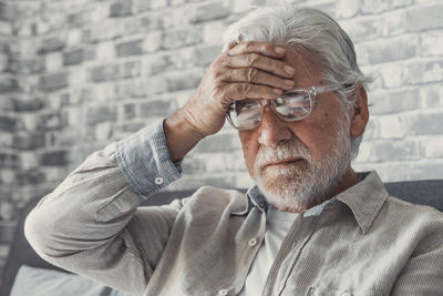 Portrait of young man looking away against wall