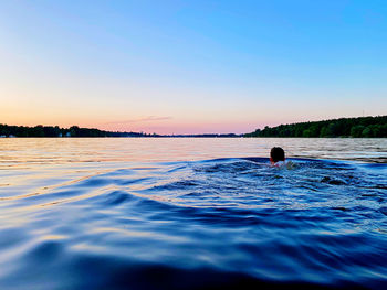 Man swimming in the sea with sunset