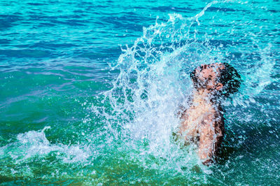 Man splashing water in sea