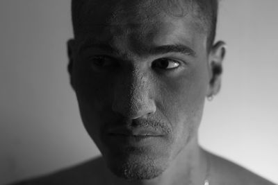 Close-up portrait of young man against gray background