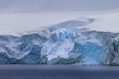 Glaciers in sea against sky