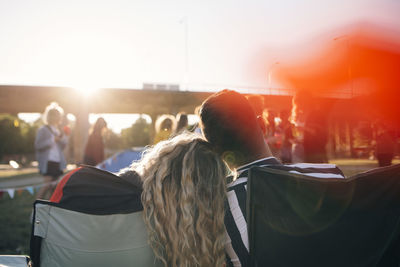 Rear view of loving couple enjoying in music festival against sky