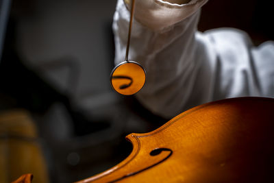 Young chinese violin maker at work in her workshop