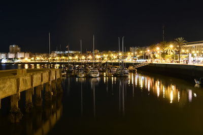 Sailboats moored in river at night