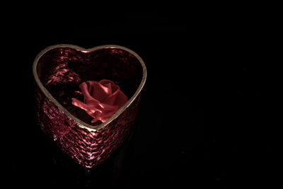 Close-up of heart shape on glass against black background