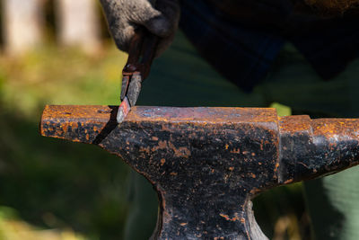 Close-up of human hand holding rusty metal