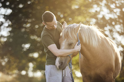 Man is embracing of therapy horse. 