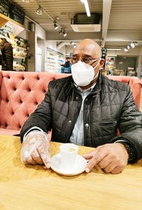 Midsection of man with coffee cup on table