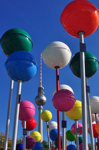 Low angle view of colorful lanterns and fernsehturm against sky