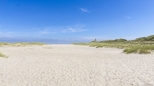 Scenic view of beach against blue sky