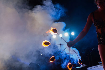 Young woman performing with fire at night