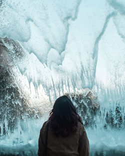 Rear view of woman standing in ice