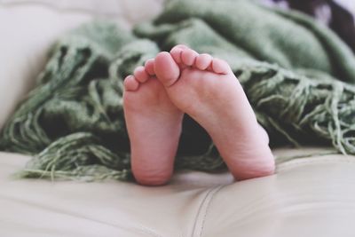 Low section of person resting on sofa