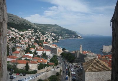 High angle view of town by sea against sky