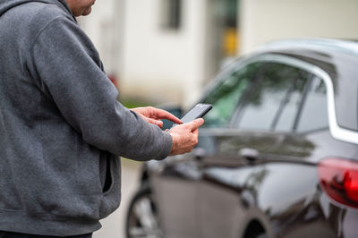 Midsection of man using mobile phone