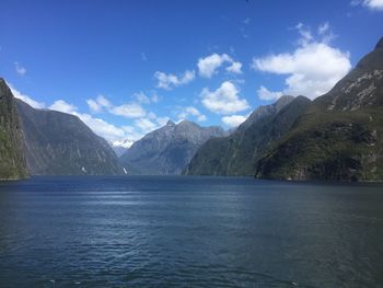 Scenic view of sea and mountains against blue sky