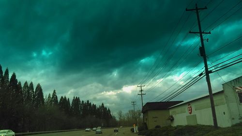 Power lines against cloudy sky