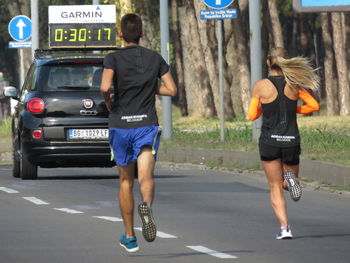 Rear view of man and woman walking on road