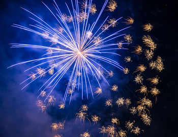 Low angle view of firework display at night