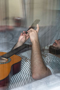 Midsection of man playing guitar