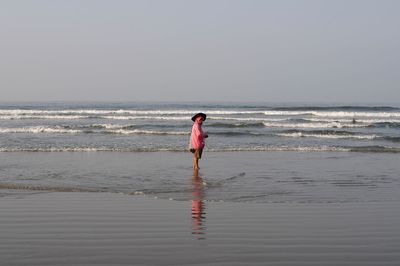 Man standing on beach against sky