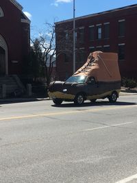 Car on street against buildings in city