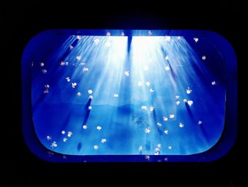 Close-up of illuminated lighting equipment against black background