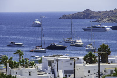 Sailboats moored on sea against sky