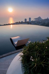 Scenic view of sea and buildings against sky during sunset