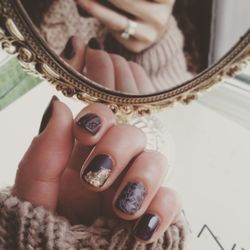 Cropped hand of woman with nail polish reflecting on mirror