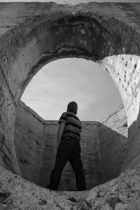 Low angle view of man standing on bridge