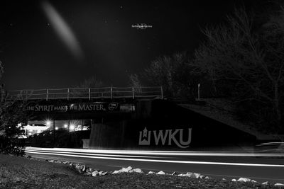 Illuminated railroad tracks against sky at night