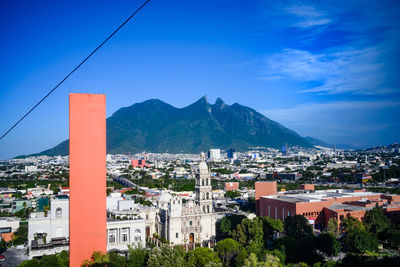 Buildings in city against blue sky