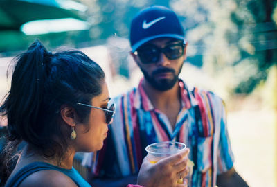 Portrait of young man drinking sunglasses